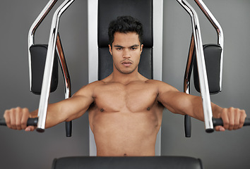 Image showing Sports, resistance exercise and man in gym for arm muscle training for health, wellness and strength. Portrait, body and young male athlete on machine with weights for bodybuilding in fitness center.