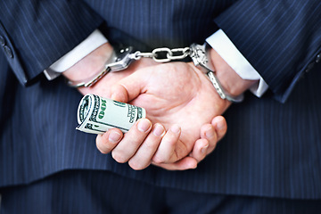 Image showing Business person, hands and money with handcuffs for bribe, secret or corruption in financial crime. Closeup or rear view of employee with roll of cash, paper or laundering finance in bribery or fraud