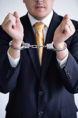 Image showing Hands, business man and handcuffs for fraud or bribery, suspicious professional deal with justice or jail. Crime, corruption or money laundering, shackles for prison with thief or criminal in finance