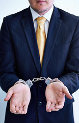 Image showing Hands, person in business and handcuffs for crime or bribery, suspicious professional deal with justice or jail. Fraud, corruption or money laundering, shackles for prison with thief or criminal