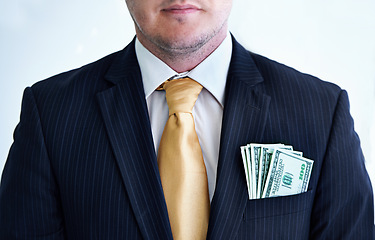 Image showing Suit, serious and businessman with money in pocket for bribe, fraud or financial scam in studio. Corruption, pay and closeup of professional male person with cash for crime by white background.