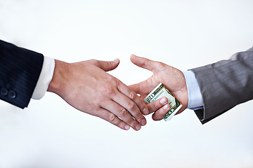 Image showing Business people, money and handshake with bribe for agreement or deal on a white studio background. Colleagues or employees shaking hands with cash, bills or paper for secret, bribery or fraud