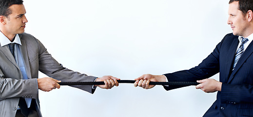 Image showing Businessman, rope and tug of war for challenge, mission or strength of rivals on a blue studio background. Man, business employees or colleagues hands pulling strong cable for competition on mockup