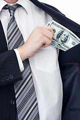 Image showing Business person, hands and money bribe in pocket for fraud, scam or secret on a white studio background. Closeup of employee with cash, dollar bills or finance in bribery, deal or financial exchange