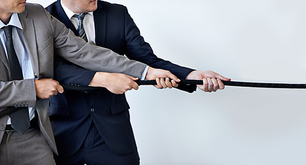Image showing Hands, partnership and tug of war with businessmen in studio for collaboration, competition or effort. Teamwork, rope and challenge with corporate people pulling together for strength or struggle