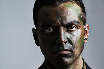 Image showing Man, portrait and camouflage with face paint for war, battle or military service on a gray studio background. Closeup of male person, army or solider with color dye for undercover disguise on mockup