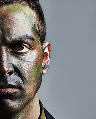 Image showing Man, portrait and soldier with face paint for camouflage, military war or battle on a gray studio background. Closeup of male person, army or commander with color dye in undercover disguise on mockup