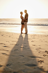 Image showing Man, woman and hug at beach for sunset for holiday happiness together, honeymoon or marriage. Couple, evening and embrace for commitment or Miami weekend for love travel, vacation or relationship