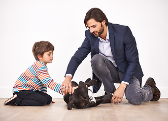 Image showing Father, child and pet dog on the floor, having fun and boy bonding with parent for leisure. Canine, kid and dad playing with animal for care, learning and love of family together at home to relax