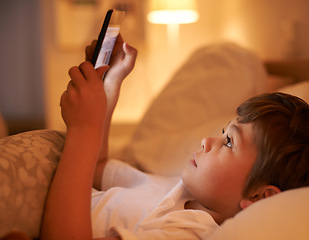 Image showing Boy, kid and tablet in bedroom at night for typing, reading or online game with app in family home. Child, bed and digital touchscreen for movie, cartoon and streaming subscription to relax in house