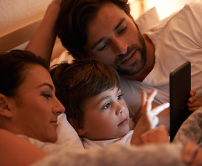 Image showing Parents, boy and tablet in bedroom at night for app, bonding and watch movies together in family house. Dad, mom and child in bed with touchscreen, cartoon or film with streaming subscription in home