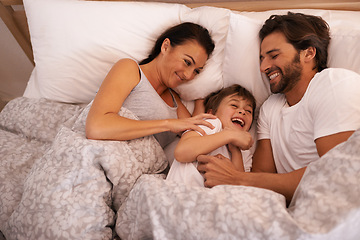 Image showing Parents, boy and tickling with laughing in bed for care, bonding or love with joke in family house. Father, mother and child with funny game, excited or happy for comic smile together in home bedroom