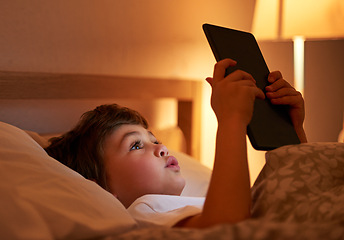 Image showing Child, tablet and bed with night, reading and technology for social media or learning. Boy, bedroom and connectivity for knowledge, growth and elearning or internet surfing at home with touchscreen