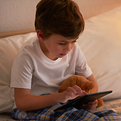 Image showing Boy, child and tablet in bed at night for typing, reading or online game with app in family home. Kid, bedroom and digital touchscreen for movie, cartoon and streaming subscription to relax in house