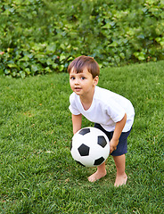 Image showing Portrait, boy or catch with soccer ball in park for fun, health or childhood development in Portugal. Happy, confident and male child with football for game or exercise in backyard or garden