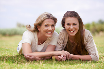 Image showing Women, mother and daughter with holding hands, grass and mature person with connection, care and love. Mom, girl and family with bonding, reunion and vacation with lawn, happy and together in spring