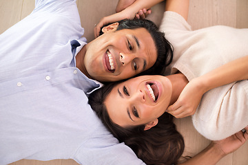 Image showing Top view, couple and laughing on floor in living room, relaxing and bonding together in romantic relationship. Above, man and woman laying on ground with happy, marriage and playful people at home.