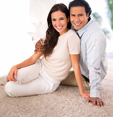 Image showing Smile, love and couple on carpet in living room at home with comfortable romance and care. Happy, marriage and portrait of young man and woman relaxing on floor mat together in lounge at house.