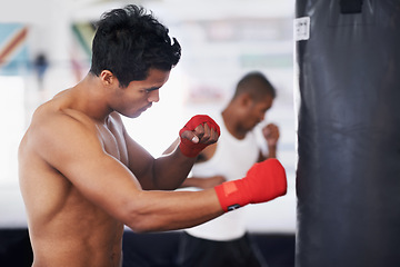 Image showing Punching bag, man and boxing fitness with at a gym for training, resilience or performance training. Sports, body and male boxer profile with punch practice for strength, energy for fighting exercise