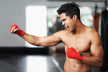 Image showing Man, training and angry in gym for boxing match, practice and determined for competition to win. Light weight champion, workout and focus for tough sport, fitness and exercise with aggression for mma