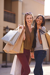 Image showing Women, happy and shopping bag in city for fashion, sale and discount with portrait outdoor in Europe. Young people or friends with smile and diversity for retail purchase, travel and style or clothes