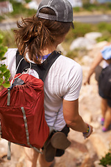 Image showing Woman, hiking and backpack on mountain for fitness, adventure or rocky trail of outdoor path in nature. Rear view of female person or hiker walking down cliff in extreme trekking or adventure outside