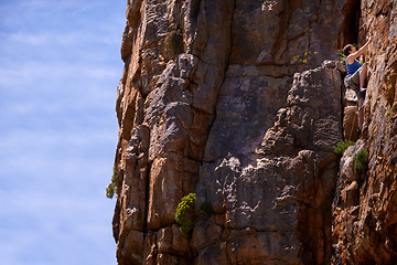 Image showing Woman, rock climbing and outdoors for adventure, fitness and exercise in the sun for extreme sports. Female person, climb wall and nature for wellness, mountain and fearless activity for strength