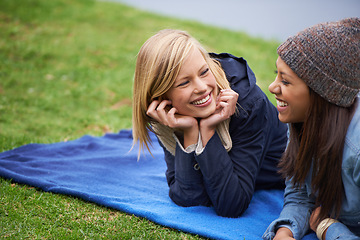 Image showing Happy, friends and relax on blanket for picnic outdoor in summer on holiday or vacation together. Women, smile and laugh in conversation in park, woods or lying on grass in backyard or garden