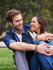 Image showing Happy, couple and relax with love on grass outdoor on summer, holiday or picnic on vacation together. Funny, conversation and man hug woman in park, woods or sitting on lawn in backyard or garden