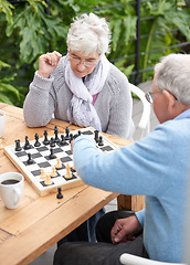 Image showing Chess, strategy and senior couple thinking while playing a board game in the backyard or bonding together. Mind, relax or challenge with an elderly man or old woman in the garden for hobby and coffee