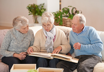 Image showing Old people, friends and photo album for memory talking in retirement on sofa together, photograph or connection. Elderly man, women and picture book in home in Canada for nostalgia, remember or love