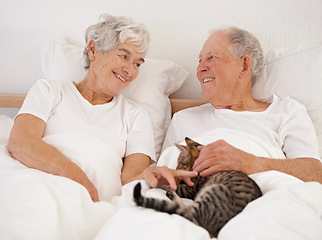 Image showing Mature couple, bed and cat for bonding, embrace and love in morning for smile and cuddle. Senior man, woman and kitty pet, happy and retirement to enjoy marriage and old people in bedroom at home