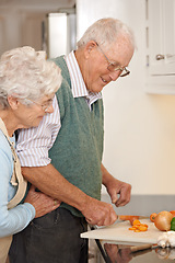 Image showing Senior couple, cutting vegetables and embrace in kitchen, food preparation and love at home. Elderly people, healthy meal and organic ingredients for nutrition, hug and diet for detox in retirement