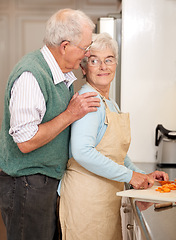 Image showing Senior couple, cutting vegetables and bonding in kitchen, food preparation and love at home. Elderly people, healthy meal and organic ingredients or carrots for nutrition, conversation and retirement