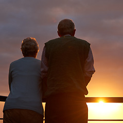 Image showing Senior couple, sunset and together on balcony in outdoors, bonding and love on vacation or holiday. Back, elderly people and dusk on terrace and together in nature, security and travel for marriage