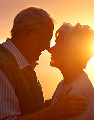 Image showing Sunset, elderly couple and embrace outdoor, love and bonding for connection together in nature. Man, woman and touch forehead for care, romance or support for commitment to relationship in retirement