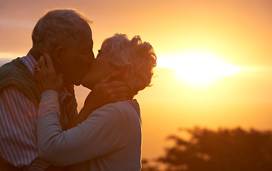 Image showing Sunset, senior couple and kiss outdoor, care or bonding together for connection in marriage. Man, woman or touch lips for love, romance or embrace for commitment to relationship in retirement on date