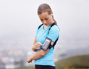 Image showing Fitness, phone and music with runner woman outdoor in mountains for health or cardio workout. Exercise, running and training with young athlete in nature or countryside for physical improvement