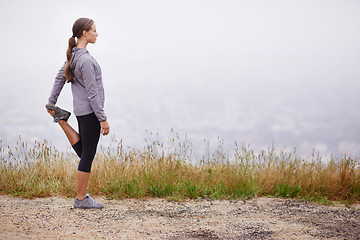 Image showing Fitness, space and stretching with runner woman outdoor on mountain trail for cardio workout. Exercise, nature and view with confident young athlete on foggy morning for running or marathon training