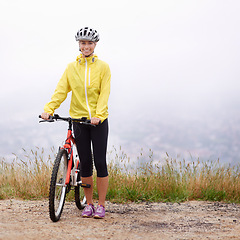 Image showing Portrait, smile and woman with bike in mountains for morning exercise, training or off road hobby. Cycling, fitness and sports with happy young athlete in countryside or nature for workout ride