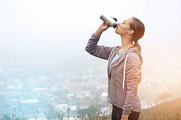 Image showing Fitness, woman and drinking water outdoor after training, workout or exercise in winter by fog. Bottle, hydration and thirsty person with liquid in nature for body health or nutrition on mockup space