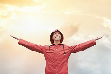 Image showing Happy woman, raincoat and freedom with weather for cloudy sky, sun or winter season in outdoor storm. Female person with smile in red waterproof rain jacket for overcast, fog or snow on mockup space