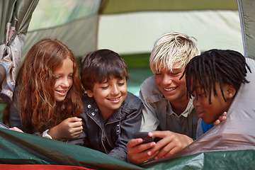 Image showing Phone, happy and children in tent for camp networking on social media, mobile app or internet. Smile, technology and young kids bonding, relax and streaming video online with cellphone on vacation.