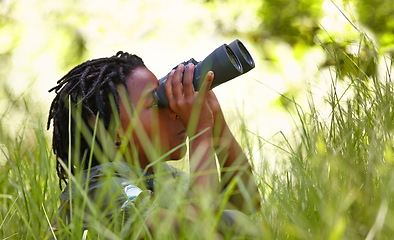 Image showing Nature, binoculars and kid in grass for exploring in park on vacation, adventure or holiday. Travel, forest and young boy child with equipment in lawn in outdoor field or woods on weekend trip.