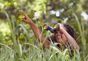 Image showing Nature, binoculars and girl in grass for exploring in park on vacation, adventure or holiday. Travel, forest and young child or kid with equipment in lawn in outdoor field or woods on weekend trip.