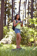 Image showing Smile, nature and portrait of child with binoculars for exploring outdoor field or forest. Happy, adventure and full length of young girl teenager with equipment for vacation, holiday or weekend trip