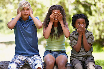 Image showing Kids, see and hear or speak no evil, forest bench and sitting down for playing, face, covering ears or mouth. Children, nature and gesture for innocence, development and learning together in nature