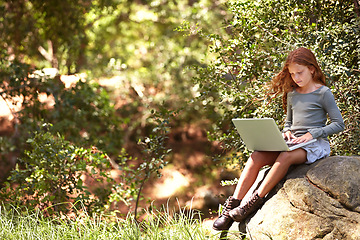 Image showing Distance learning, laptop or girl child in nature for research, development or online assignment in a forest. Remote, pc or kid in park for elearning, reading or web communication with school friends