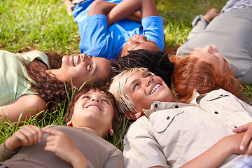 Image showing Kids on grass, summer and relax with happiness, smile and weekend break with youth and peaceful. Children, boys and girls in a park and excited with games and looking up with nature, joy or diversity