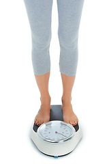 Image showing Woman, legs and scale in studio for weight loss, healthcare and wellness for vitality. Female person, diet and check calories for slim body for self care, achievement and closeup on white background